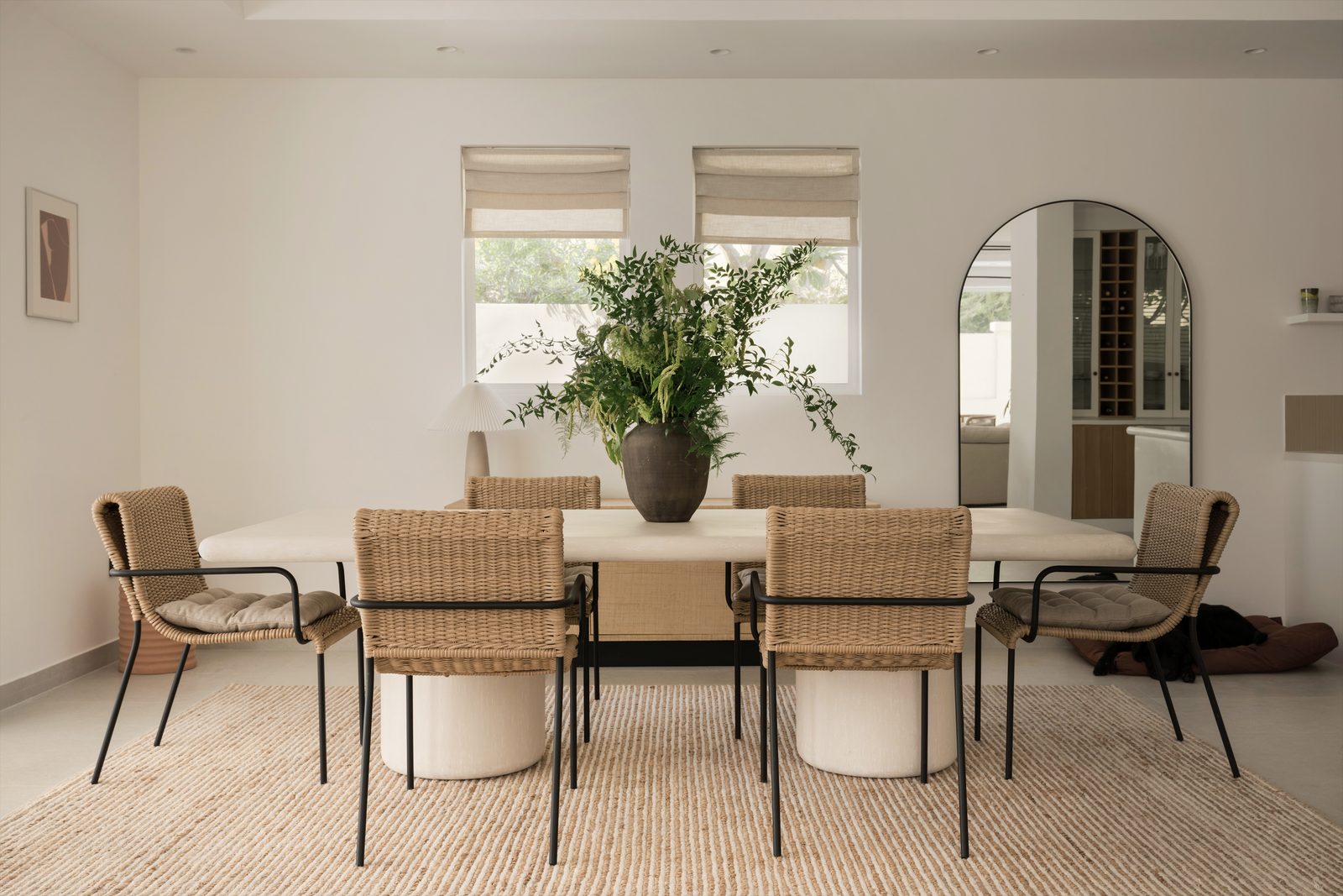 Dining room with rattan chairs, a long table and a potted plant